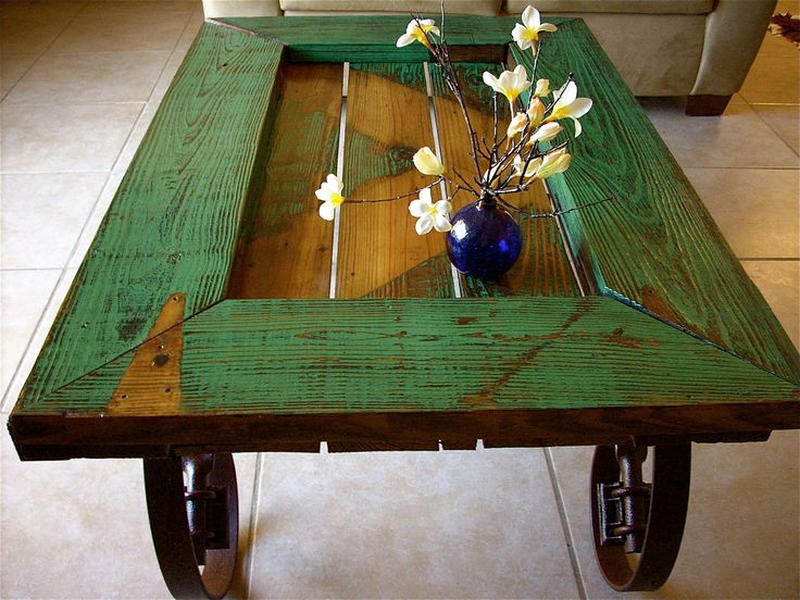 A coffee table made out of reclaimed wood and wheels, repurposed.