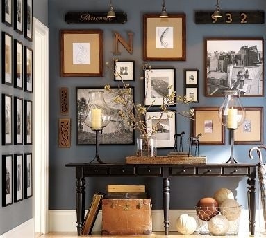 A unique gallery hallway with framed pictures and a table.