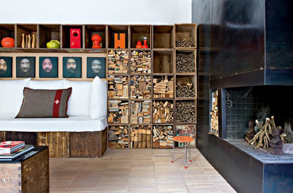 A living room with bookshelves and fireplace featuring repurposed wood crates.