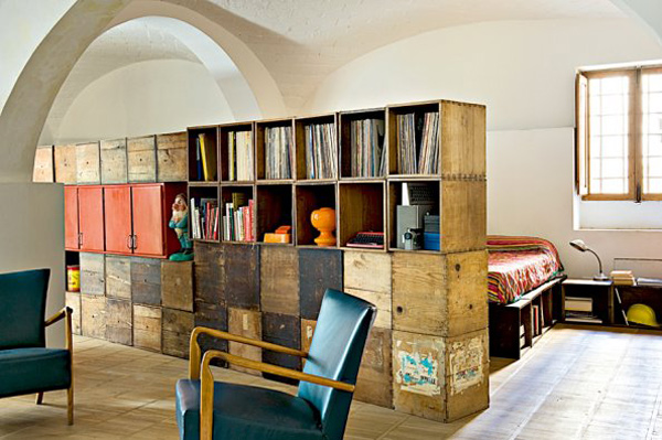 Repurpose wood crates in a room with bookshelves and a chair.