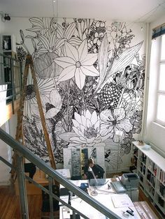 A room with a large floral mural on the wall.