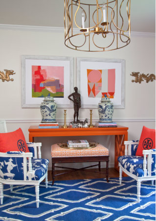 A bold and beautiful blue and orange rug in a living room.