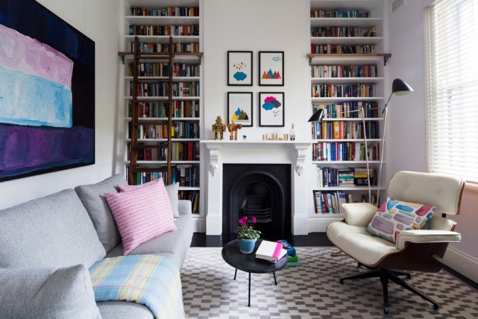 A living room with a bookcase and fireplace.