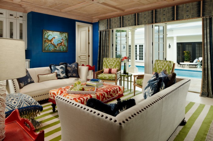 A living room with bold and beautiful blue walls and colorful furniture, showcasing Palm Beach style.