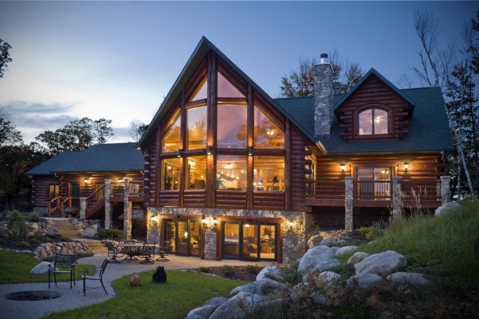 A luxurious log home at dusk, offering exceptional amenities.