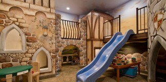 An elaborate tudor-village playroom with slide and lofts (homedit).