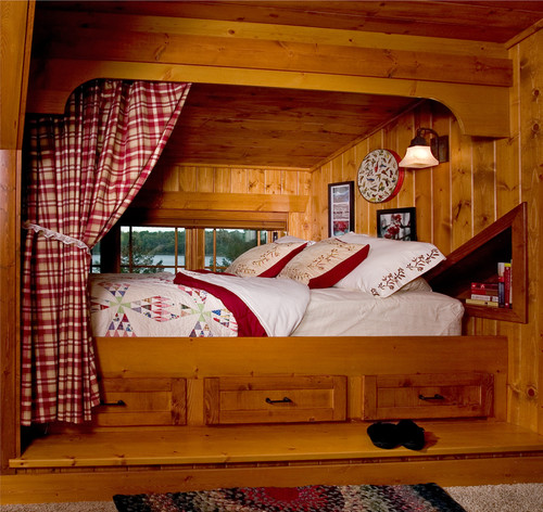 A cozy bed in a room with wood paneling and inviting nooks.