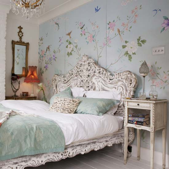 A bedroom with floral wallpaper.