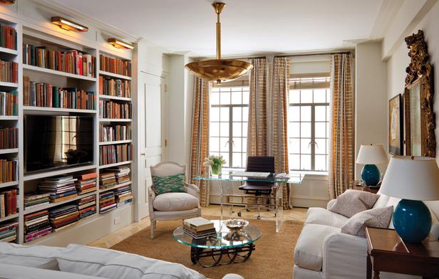 A white living room with bookshelves and a coffee table featuring a bookcase.