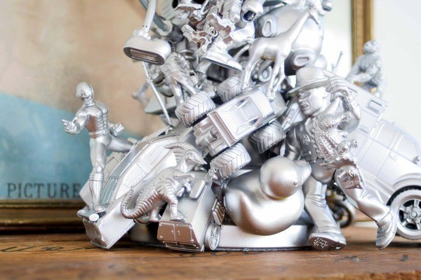 A silver car statue displayed on a table.
