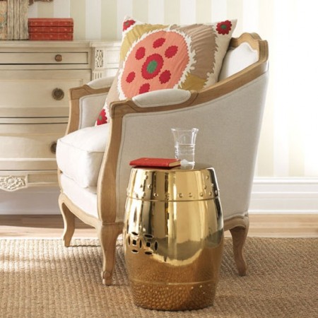 A gold barrel side table in a living room adds shimmer to your home.