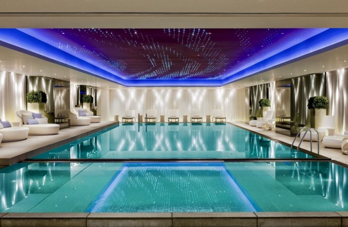 An indoor swimming pool in a luxury home with amenities.