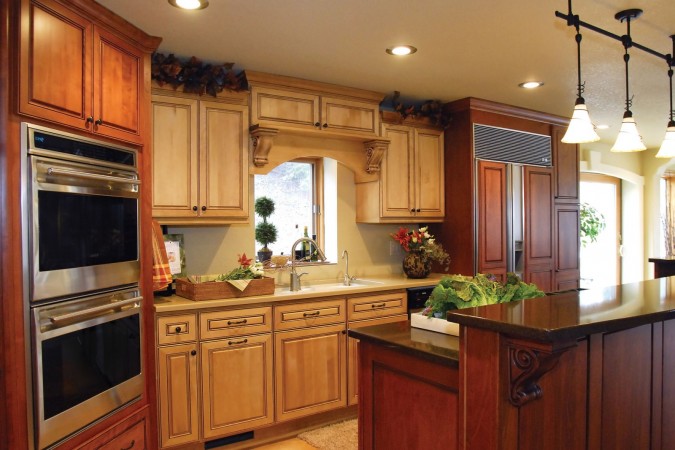 Rich dark stained cabinetry mixes with lighter wood in this kitchen