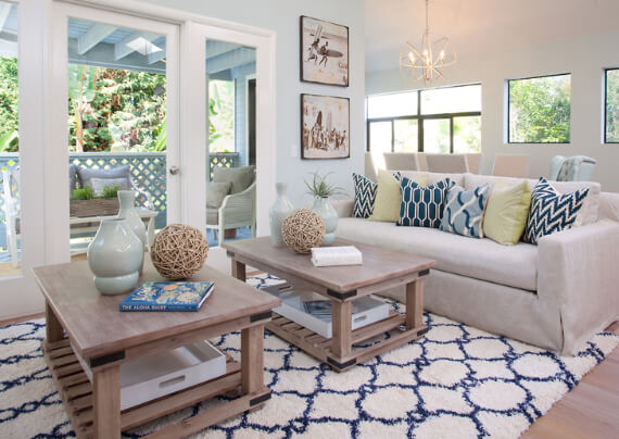 A living room with a white couch and blue rug offers a chic beach look.