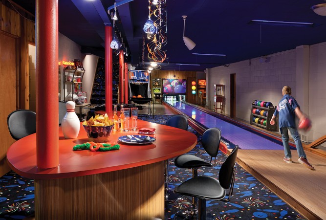 A luxury bowling alley with a table and chairs.