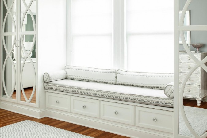 A window seat in a serene white bedroom.