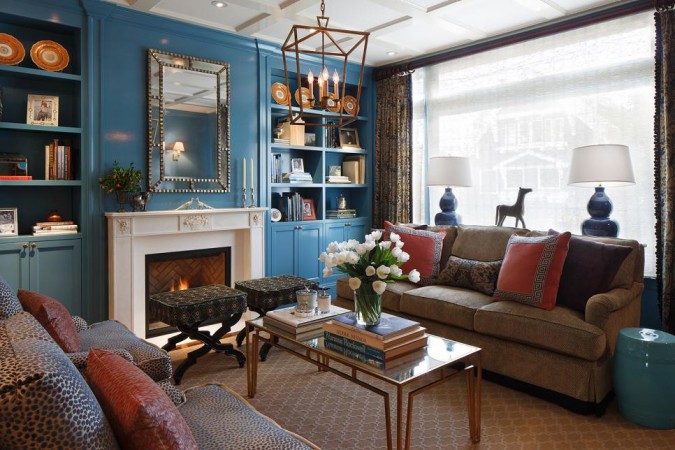 A living room with blue walls and a fireplace featuring shimmer and luster.