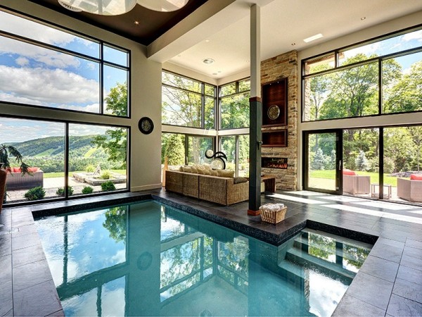 A luxury home with an indoor swimming pool and large windows.