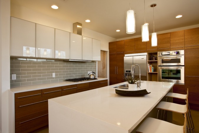 Glossy white combined with wood cabinetry enhance this modern kitchen 