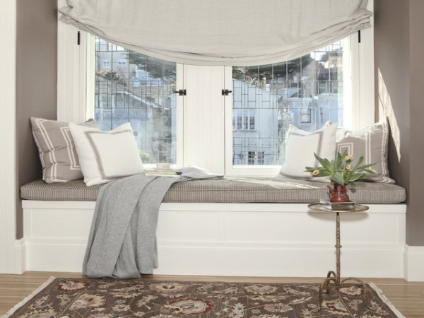 A cozy window seat with a rug and a view.