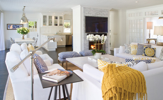 A living room with white furniture and yellow accents, achieving a chic beach look.