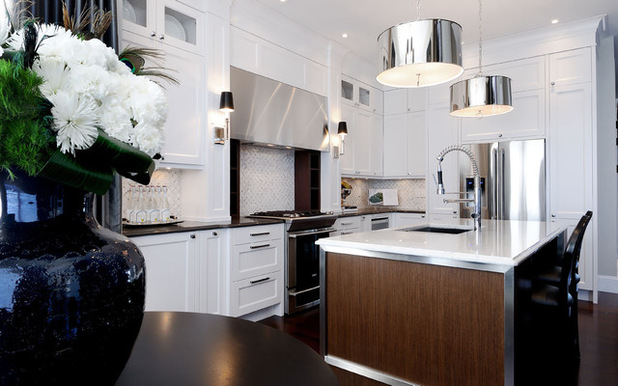 A white kitchen with stainless steel appliances and a black vase adds shimmer and luster to your home.