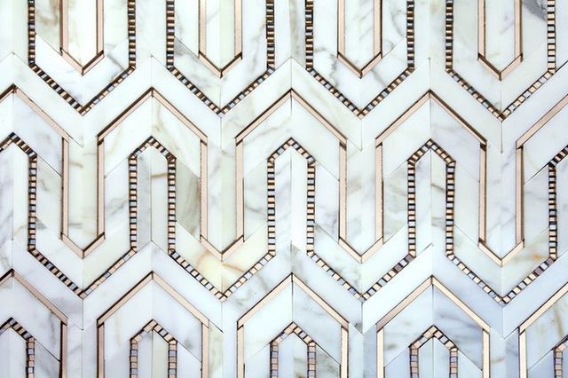 A close up of a white and gold marble tile with Gatsby style.