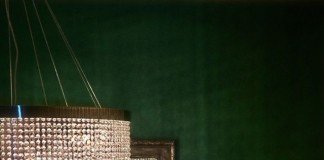 Emerald wallpaper behind glamorous crystal chandelier (fashiongonerogue).