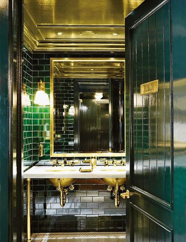 A glamorous bathroom with emerald green tiled walls.