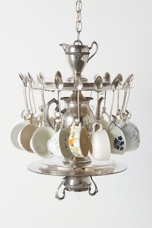 A repurposed chandelier featuring tea cups and saucers as hanging decorations.