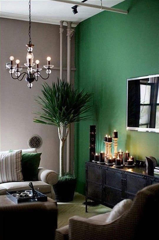 A glamorous living room with emerald green walls and furniture.
