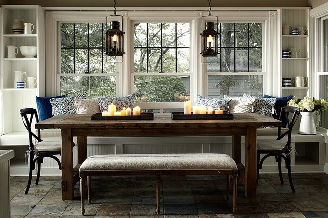 A dining room with a table and chairs in front of windows, highlighting the benefits of window seats.