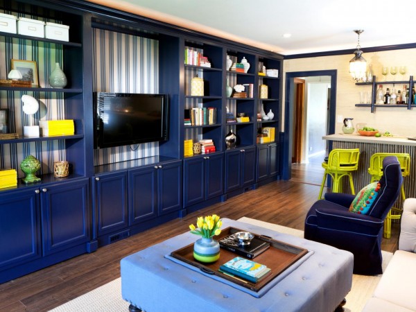 A living room with blue cabinets and a TV featuring a bookcase.