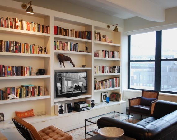 A living room with bookshelves as a prominent feature wall.