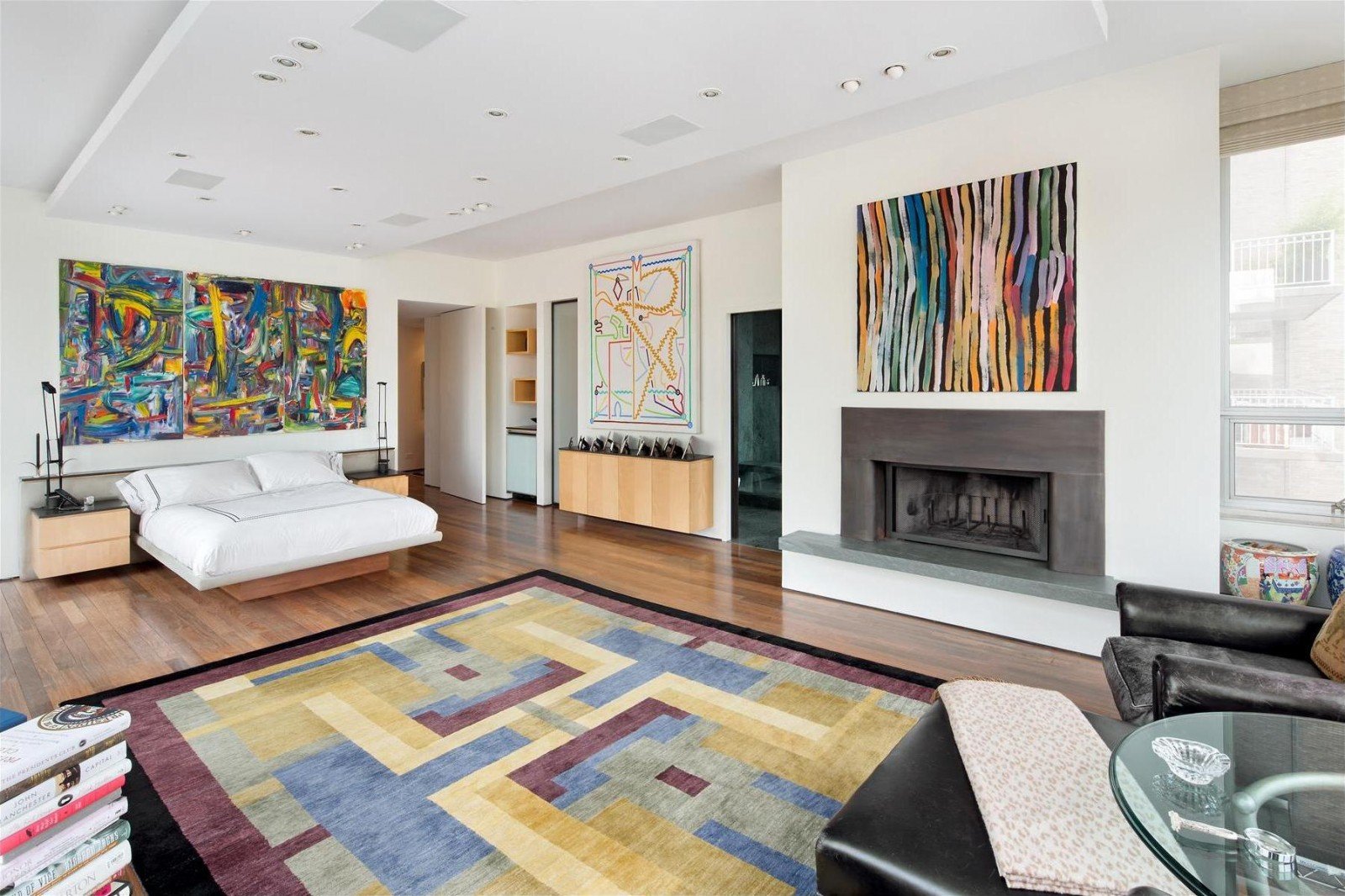 A unique bedroom with a fireplace and a colorful rug.