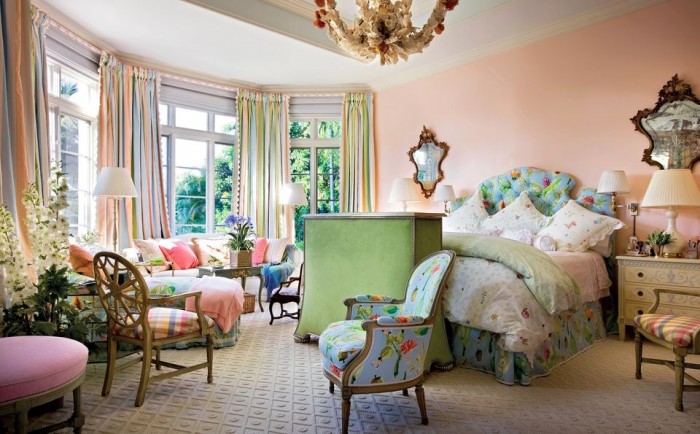 A bold and beautiful pink and green bedroom with a chandelier in Palm Beach style.