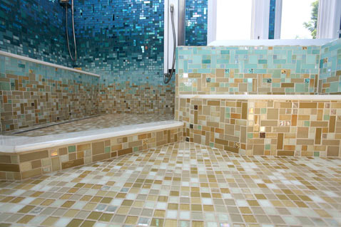 A beach-themed bathroom with a tiled floor and a glass shower.