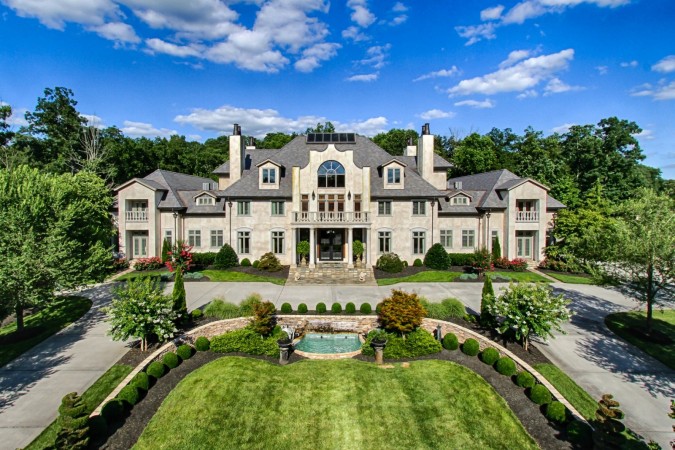 A luxurious aerial view of a large mansion with exquisite amenities.