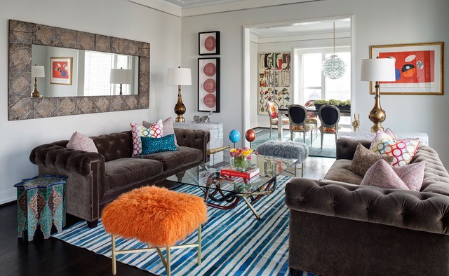 A living room with quirky and colorful couches and a funky rug.