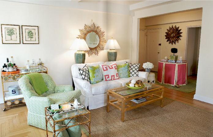 A living room with a bold and beautiful white couch and a green chair in Palm Beach style.