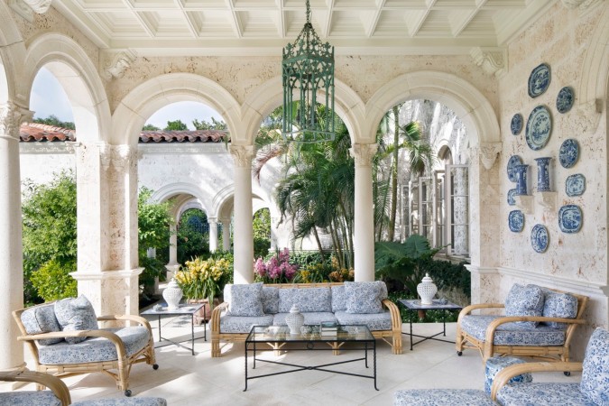 An ornate patio with bold and beautiful blue and white furniture in Palm Beach style.