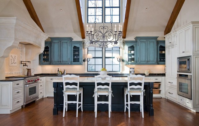 Trend Alert: A kitchen with blue cabinets and a chandelier.