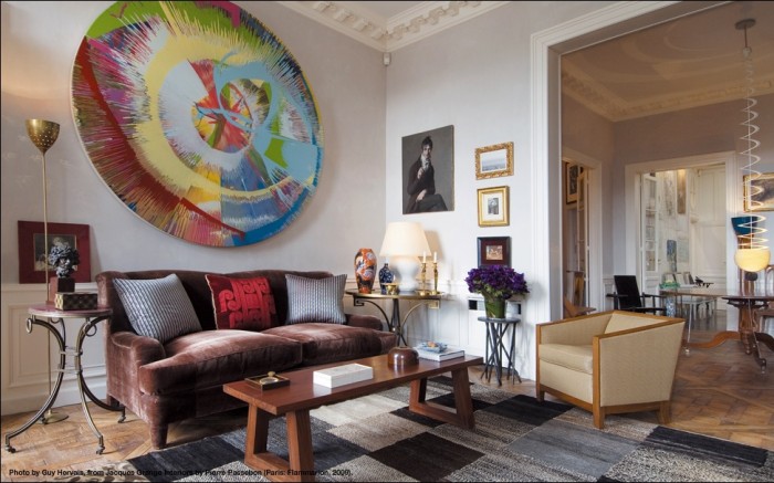 A living room with a large painting on the wall, showcasing Jacques Grange's designer focus.