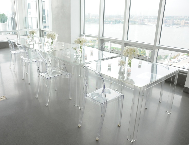 A table with transparent chairs creating space and providing a view of the city.