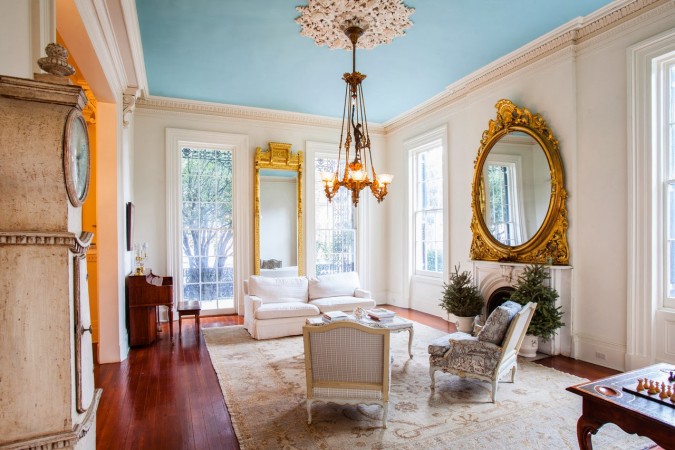 A living room with an ornate mirror and blue ceiling, paying tribute to New Orleans on Mardi Gras.