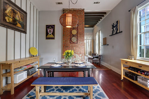 A dining room with a blue rug and brick walls, paying tribute to New Orleans on Mardi Gras.