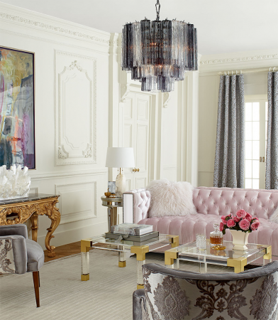 A vibrant living room adorned with pink furniture and a dazzling chandelier.
