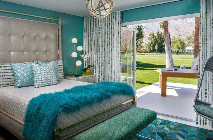 A bedroom with luxurious turquoise and gold accents.