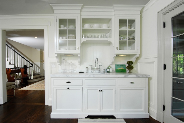 A white kitchen with cabinets and a counter top that utilizes two resale value boosting solutions for unused spaces.