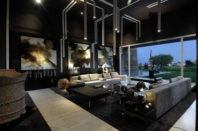 A dark and moody living room with black furniture and artwork.